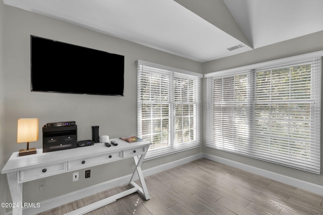 office area with lofted ceiling, plenty of natural light, and light hardwood / wood-style floors