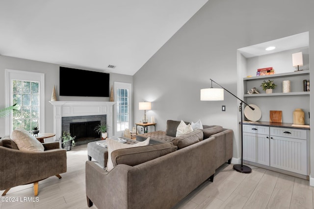 living room with vaulted ceiling and light wood-type flooring