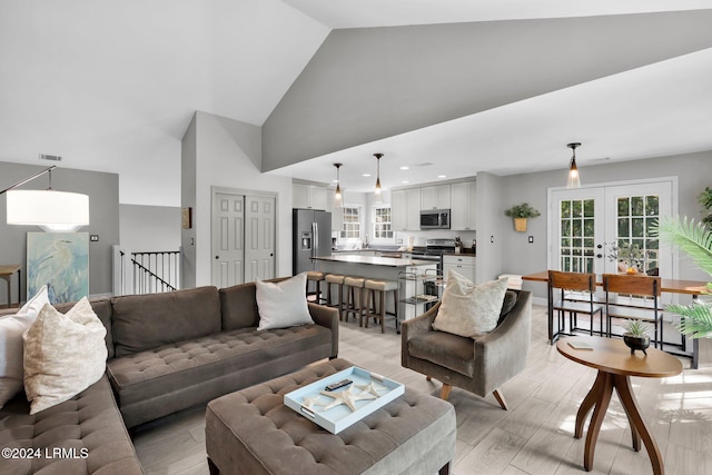 living room with high vaulted ceiling and french doors