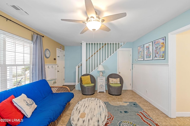 living area featuring light tile patterned floors and ceiling fan