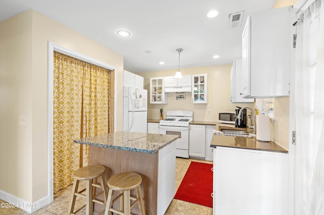 kitchen with stone counters, sink, white cabinets, and white appliances