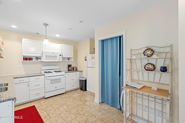 kitchen with light stone countertops, white cabinets, white appliances, and decorative light fixtures