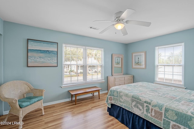 bedroom with multiple windows, ceiling fan, and light wood-type flooring