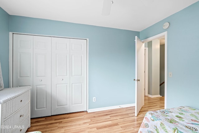 bedroom with ceiling fan, light hardwood / wood-style floors, and a closet