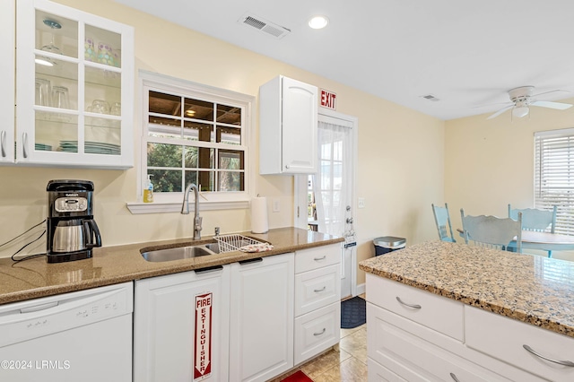 kitchen with sink, dishwasher, ceiling fan, white cabinetry, and light stone countertops