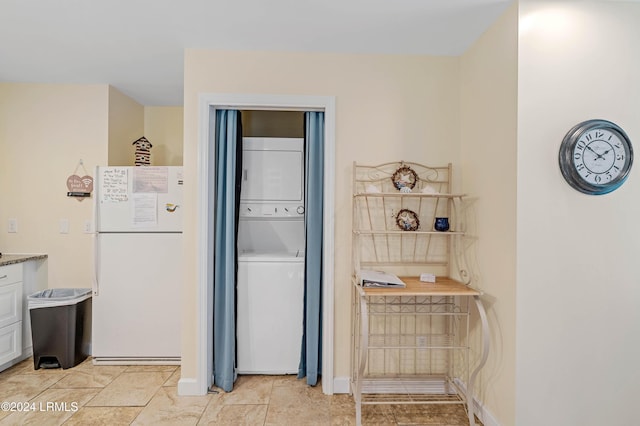 kitchen featuring white refrigerator, white cabinetry, and stacked washer and clothes dryer