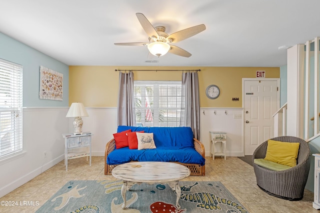 living area featuring light tile patterned floors and ceiling fan