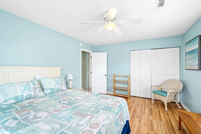 bedroom with light hardwood / wood-style floors, a closet, and ceiling fan