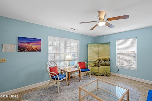 living area with ceiling fan and light tile patterned floors