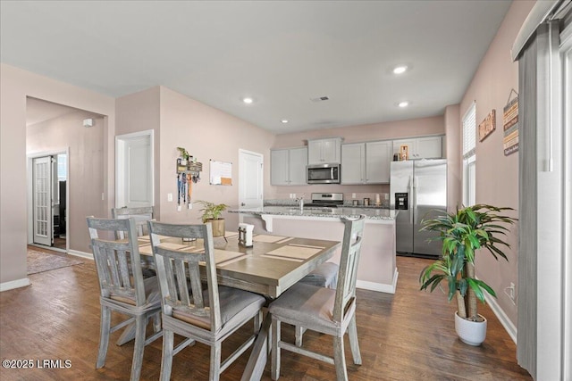 dining space featuring dark wood-style floors, visible vents, recessed lighting, and baseboards