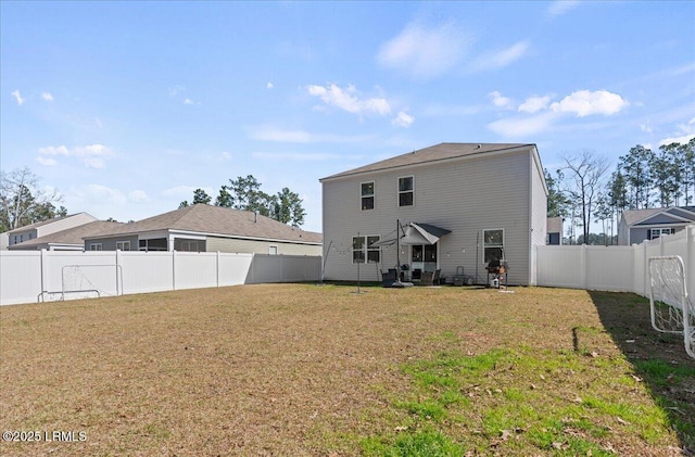 back of house with a yard and a fenced backyard