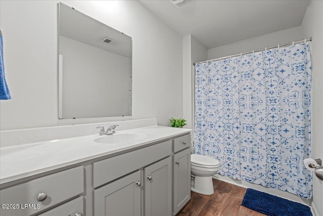 bathroom featuring toilet, vanity, a shower with curtain, and wood finished floors