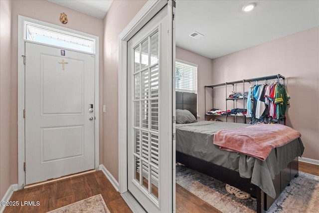 foyer featuring visible vents, baseboards, and wood finished floors