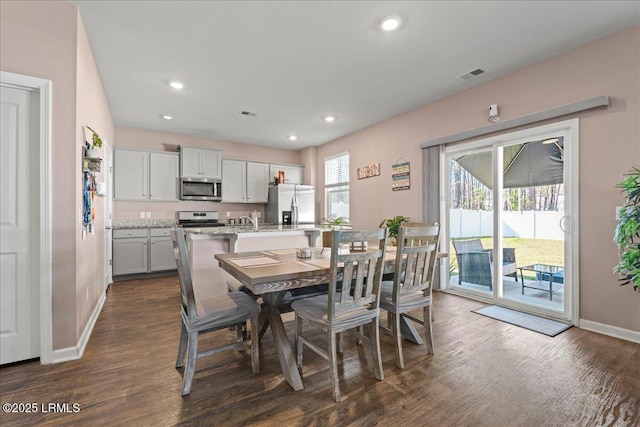 dining room with dark wood-style floors, visible vents, recessed lighting, and baseboards