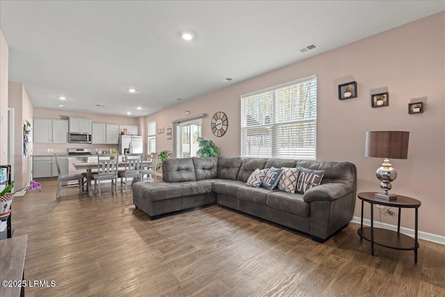 living room with visible vents, recessed lighting, baseboards, and wood finished floors