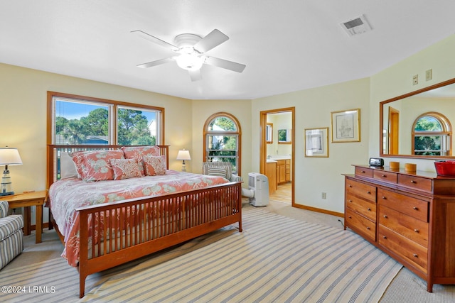 carpeted bedroom featuring ensuite bath and ceiling fan