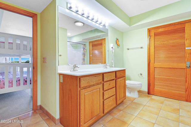 bathroom featuring vanity, a shower, tile patterned floors, and toilet