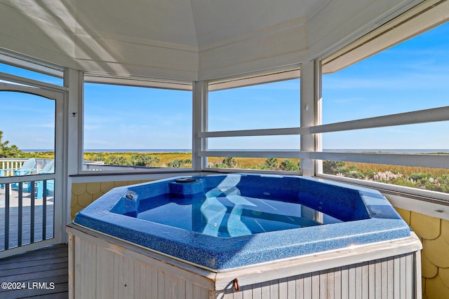 sunroom with a hot tub and a healthy amount of sunlight