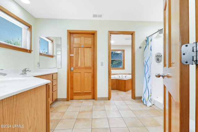 bathroom featuring tile patterned floors, shower with separate bathtub, vanity, and a wealth of natural light