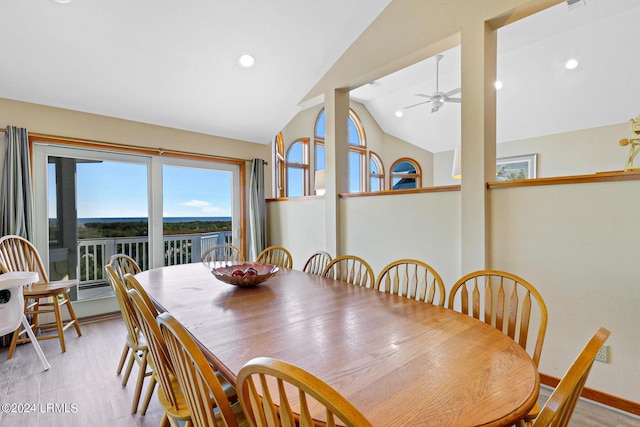 dining space featuring ceiling fan, vaulted ceiling, and light hardwood / wood-style flooring