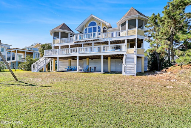 back of property with a sunroom, a yard, and a deck