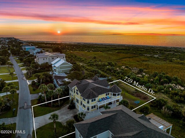 aerial view at dusk featuring a water view