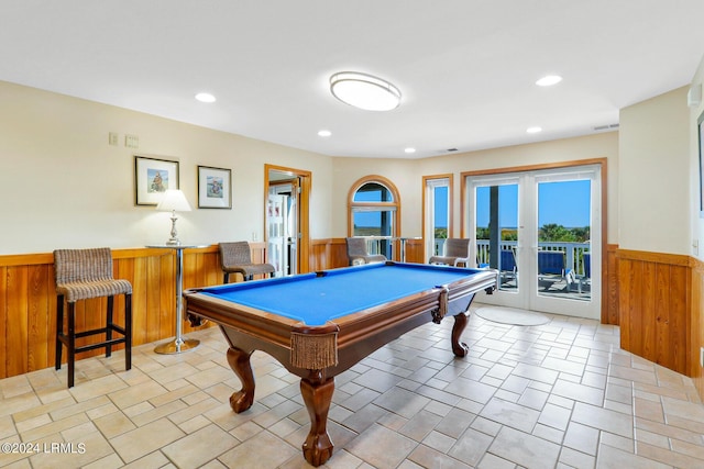 rec room with pool table, wood walls, and french doors