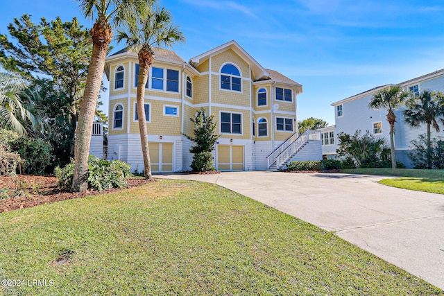 view of front of house with a garage and a front lawn