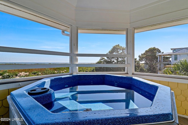 view of pool featuring a water view and a hot tub