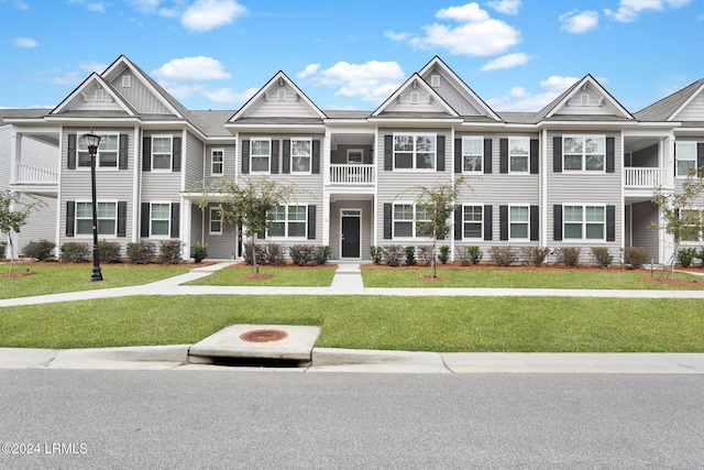 townhome / multi-family property featuring a fire pit and a front lawn