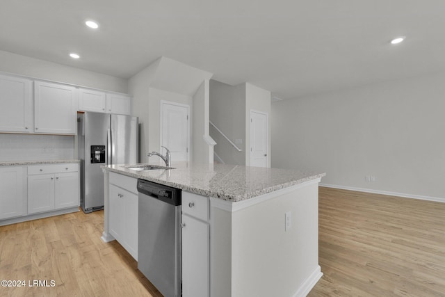 kitchen featuring an island with sink, white cabinetry, sink, stainless steel appliances, and light hardwood / wood-style flooring