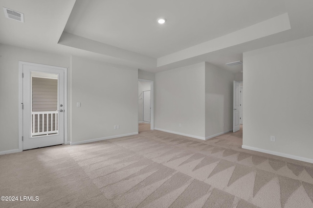 carpeted empty room featuring a raised ceiling