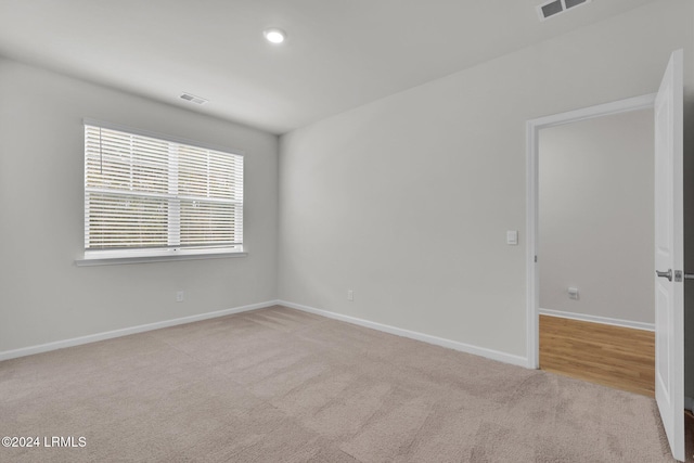 unfurnished room featuring light colored carpet