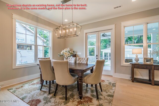 dining space with ornamental molding and light hardwood / wood-style flooring