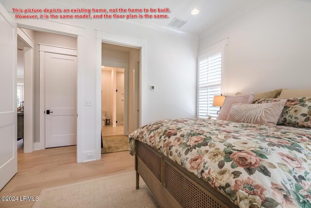 bedroom featuring ornamental molding and light hardwood / wood-style floors