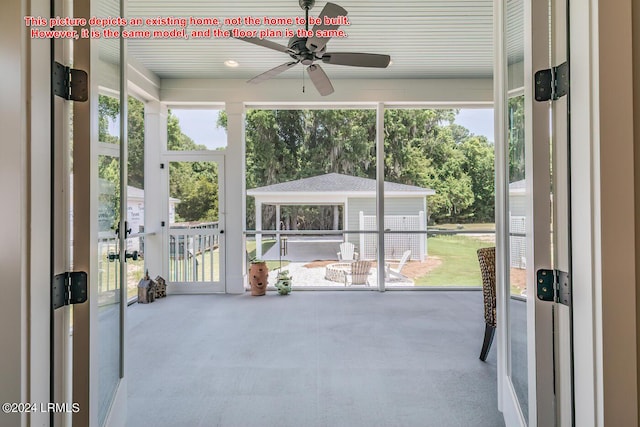 unfurnished sunroom with ceiling fan