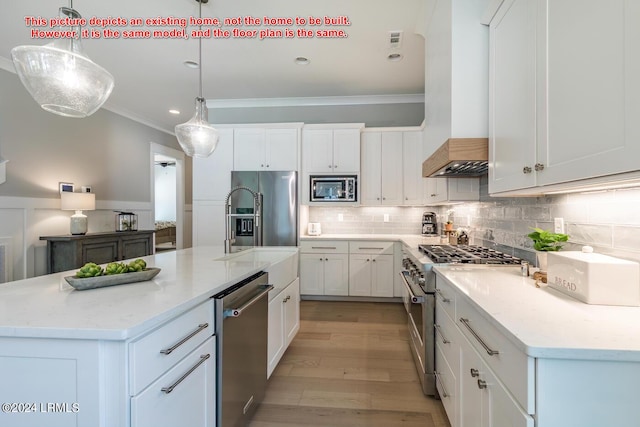 kitchen featuring a kitchen island with sink, high end appliances, light stone countertops, white cabinets, and decorative light fixtures