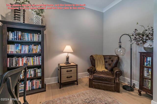 sitting room with crown molding and wood-type flooring