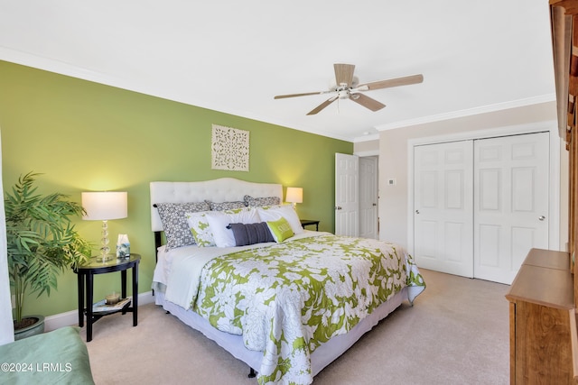 carpeted bedroom with ceiling fan, ornamental molding, and a closet