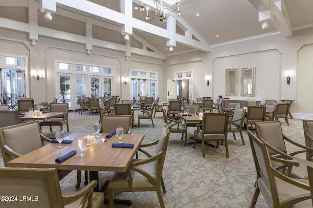 dining area featuring french doors, light carpet, a notable chandelier, beamed ceiling, and a high ceiling