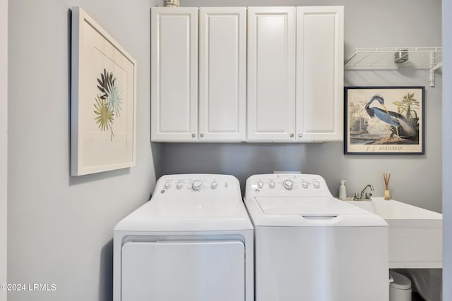 washroom with cabinets, separate washer and dryer, and sink