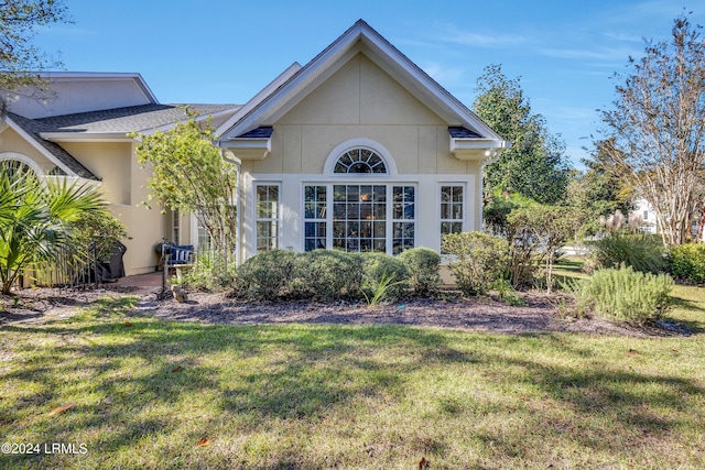 rear view of house featuring a yard