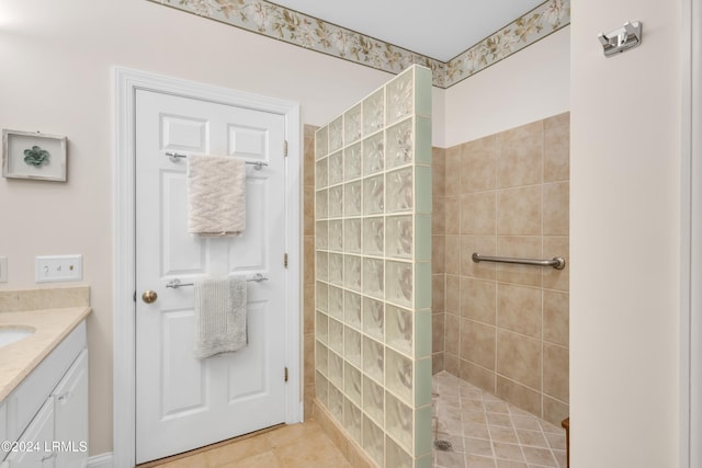 bathroom featuring vanity, tile patterned flooring, and tiled shower