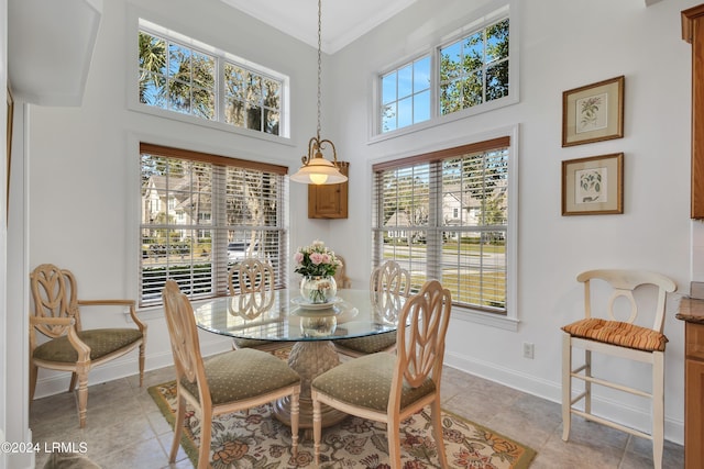 dining area featuring a towering ceiling and light tile patterned floors