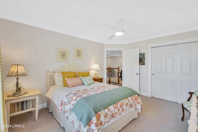 carpeted bedroom with ornamental molding, a closet, and ceiling fan