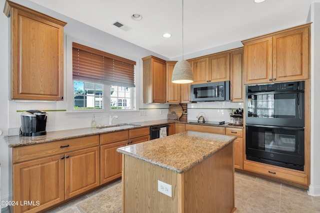 kitchen with pendant lighting, sink, a center island, light stone countertops, and black appliances