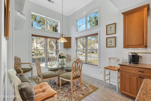 dining space featuring light tile patterned floors and a towering ceiling