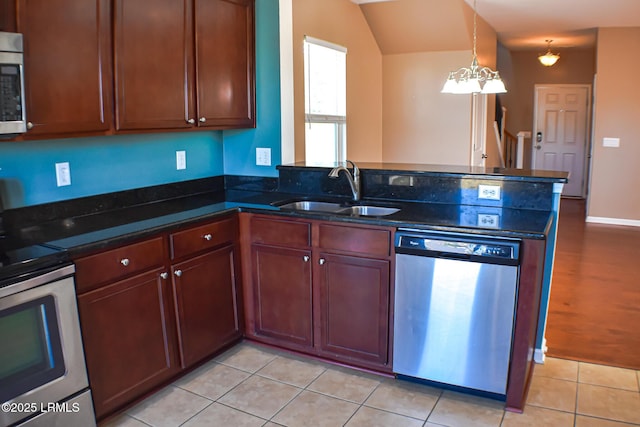 48 Pennyroyal Way, Beaufort, SC 29906 - kitchen with stainless steel appliances, a peninsula, dark stone counters, decorative light fixtures, and light tile patterned flooring