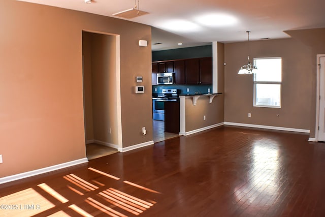 48 Pennyroyal Way, Beaufort, SC 29906 - kitchen with appliances with stainless steel finishes, a kitchen bar, dark wood-style flooring, a chandelier, and decorative light fixtures