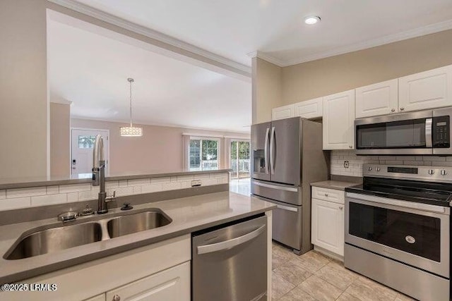 1 Wateree Ct, Beaufort, SC 29902 - kitchen with stainless steel appliances, tasteful backsplash, white cabinetry, crown molding, and hanging light fixtures